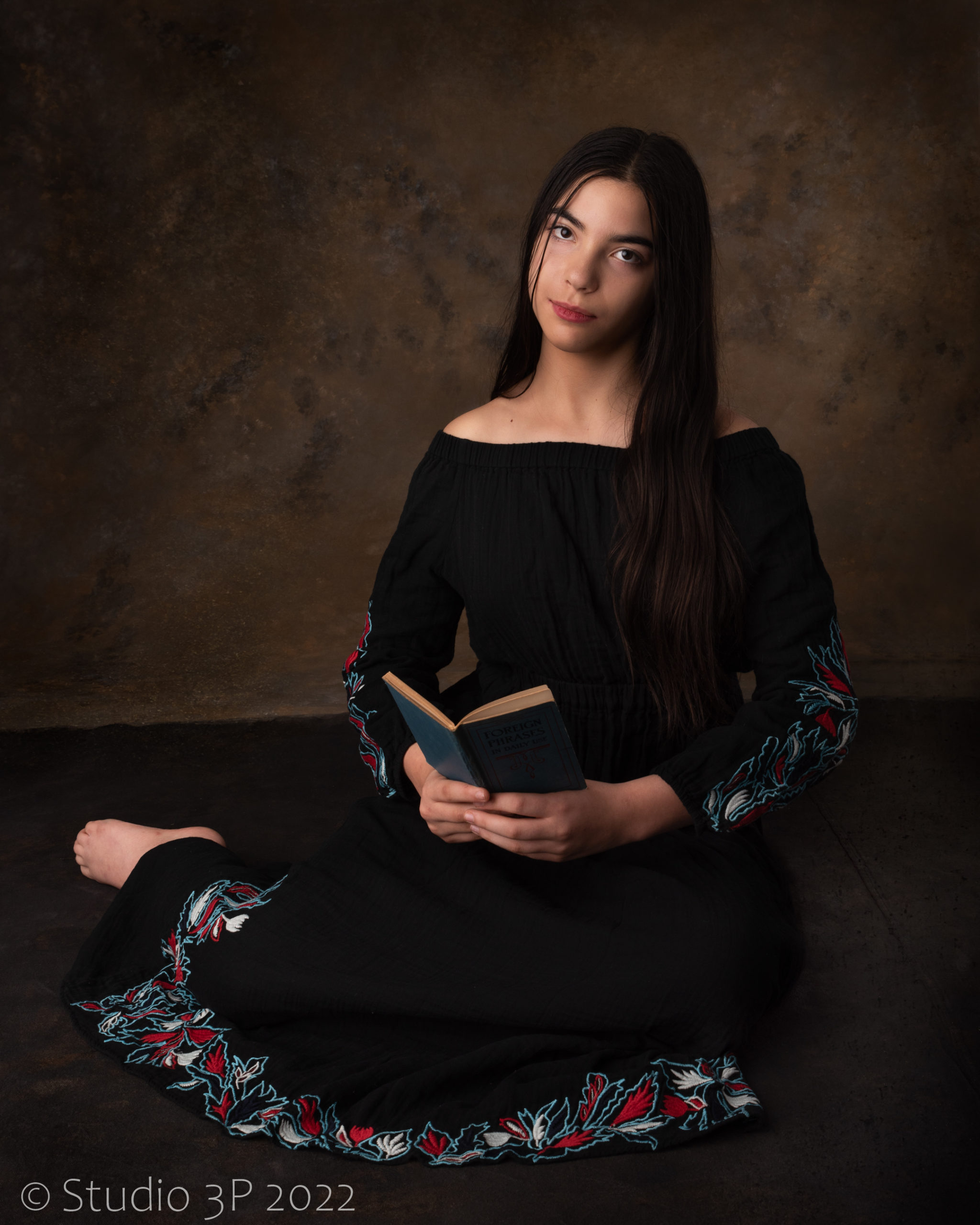 Young woman poses with book in Black 